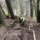 MGH Forestry crew wearing high viz and safety boots while repairing steps in a forest trail in the Trossachs, Scotland